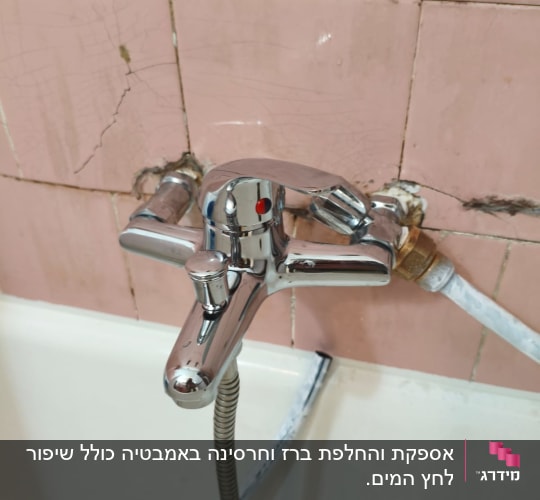 ברז אמבטיה מותקן על קיר עם אריחים סדוקים